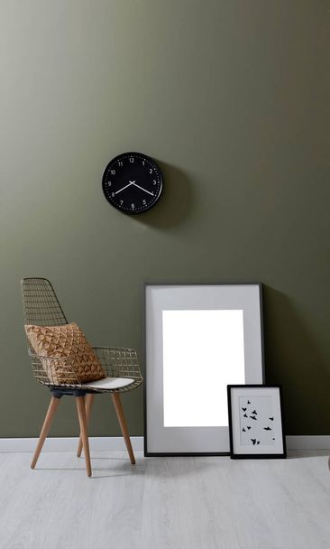 Πράσινο τοίχο, καρέκλα, καρέ μαξιλάρι ρολόι νεκρή φύση. - Φωτογραφία, εικόνα