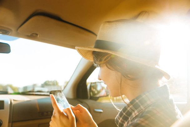 Image of young woman 20s wearing straw hat using mobile phone, w - Foto, Imagem