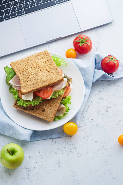 healthy sandwich with greens and ham with tomatoes and cheese on plate near laptop, Lunch ideas for work - Photo, Image