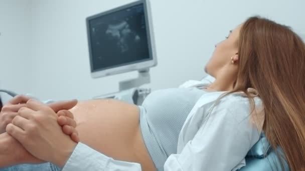 妊娠中の美しい女性に超音波手順を実行する医師の女性. - 映像、動画