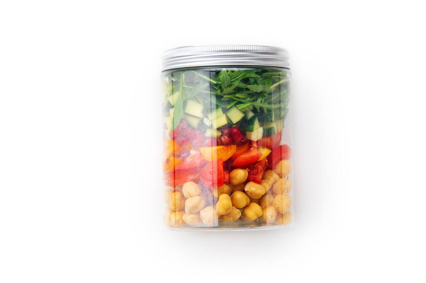 Healthy salad with chickpeas and arugula and pieces of vegetables in jar isolated on white background, close-up . Take away easy lunch concept - Photo, Image