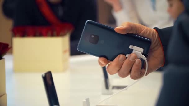 Persona mira en el nuevo teléfono móvil en el mercado
 - Imágenes, Vídeo