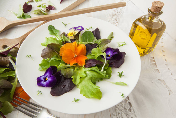 Salade de laitue et de fleurs sur fond blanc boisé printemps, Pâques
 - Photo, image