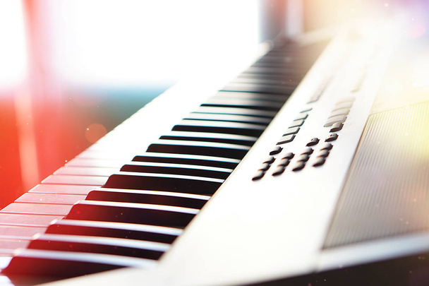 Πληκτρολόγιο συνθεσάιζερ πιάνο σε μακροεντολή ακτίνες του ήλιου. - Φωτογραφία, εικόνα