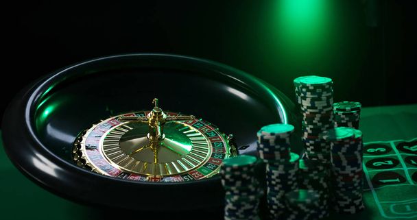  Casino background, poker Chips on gaming table, roulette wheel in motion, - Photo, Image