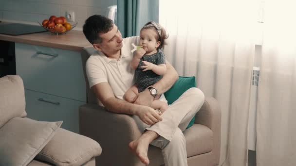 Молодий тато тримає в руках свою доньку
 - Кадри, відео