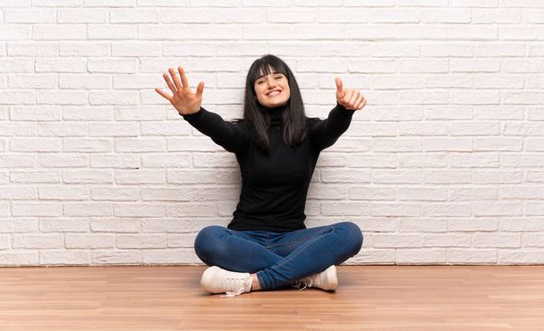 Женщина, сидящая на полу, считая шесть пальцев
 - Фото, изображение