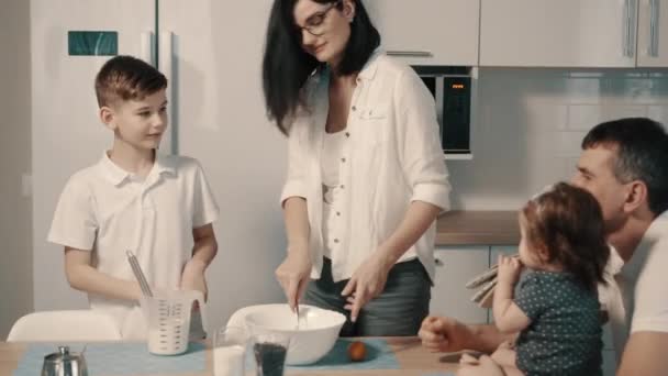 Familia joven preparando comida en la cocina en casa
 - Imágenes, Vídeo