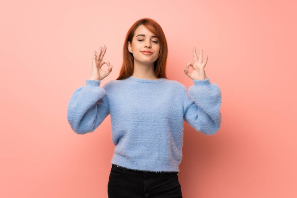 Young redhead woman over pink background in zen pose - Photo, Image