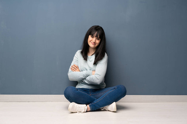 Femme assise sur le sol avec les bras croisés et impatiente
 - Photo, image