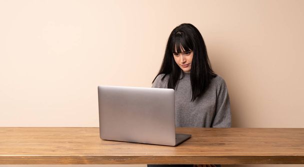 Jovem mulher trabalhando com seu retrato laptop
 - Foto, Imagem