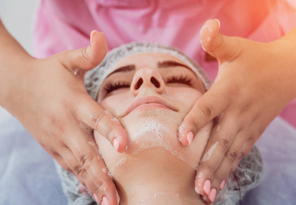 Procedimento cosmético facial no salão de spa. O procedimento para aplicar uma máscara no rosto de uma mulher bonita. Tratamentos Spa
 - Foto, Imagem