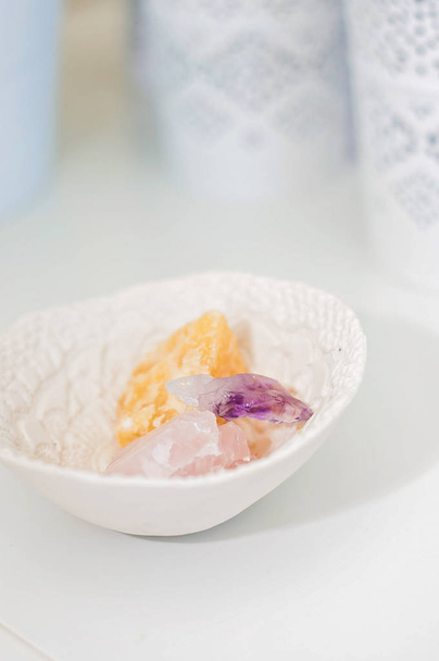 Healing crystals and gemstones on a white table: Amethyst Point, Calcite and rose quartz are bringing positive energy to support inner strength - Photo, Image