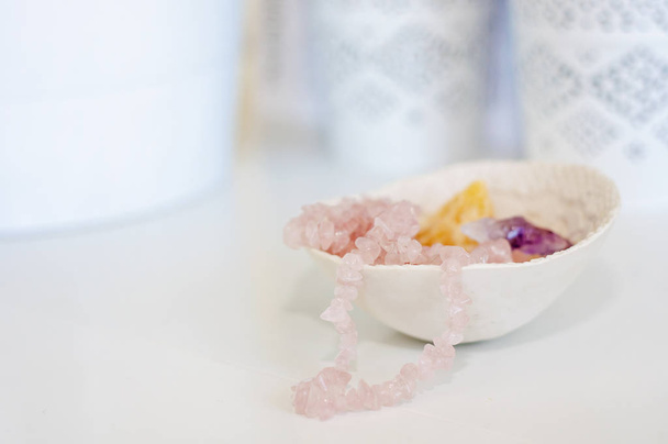 Cristales curativos / piedras preciosas y un collar de cuarzo rosa en un whi
 - Foto, imagen