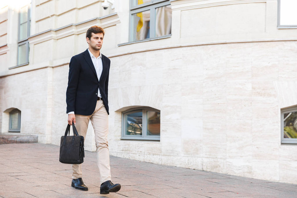 Confident young business man carrying bag - Foto, immagini