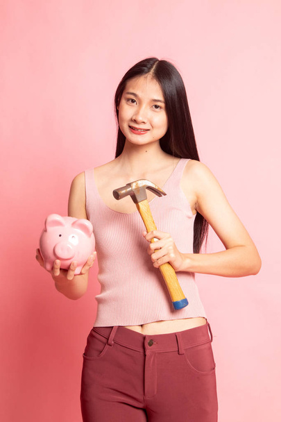 Asian woman with pig coin bank and hammer. - Photo, Image