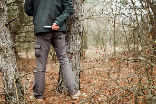 άνθρωπος με μαχαίρι κρύβονται στο δάσος το φθινόπωρο και πρόκειται να κάνει ποινικό - Φωτογραφία, εικόνα
