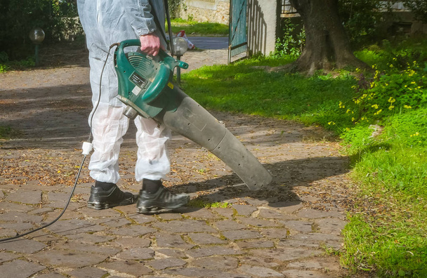 Man using a leaf blower - Fotoğraf, Görsel