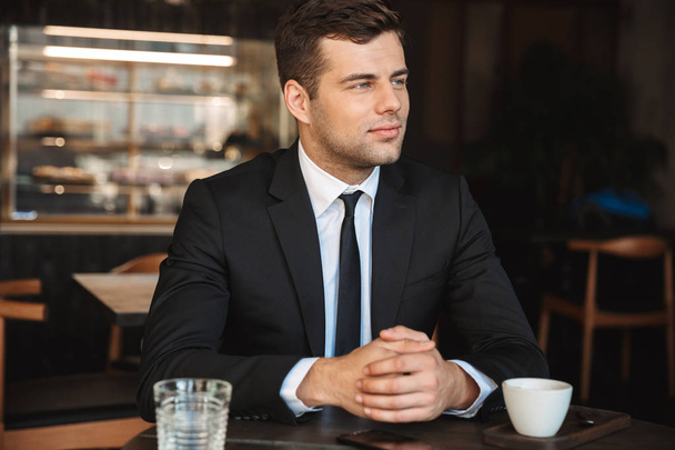 Handsome young businessman in formal clothes indoors in cafe. - Fotoğraf, Görsel