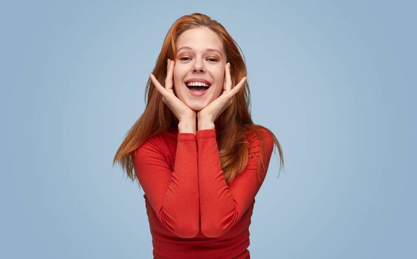 Playful happy woman with hands on cheeks  - Фото, изображение