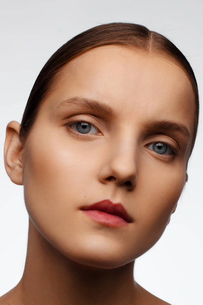 Retrato de close-up de um belo modelo com maquiagem limpa e cabelos coletados, fotografado em um estúdio de fotografia
 - Foto, Imagem