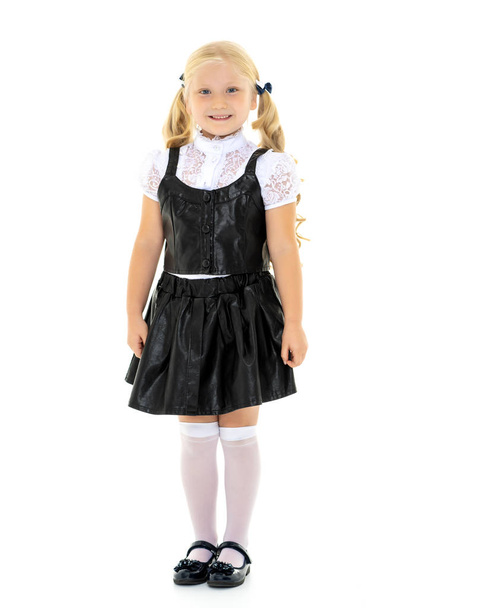 Beautiful little girl in a school uniform. - Zdjęcie, obraz