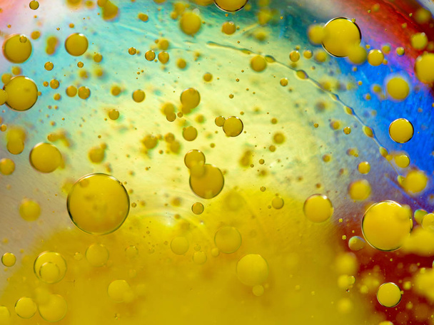 Drops of yellow paint, an abstract background. Close up shot. Blurred background. Selective soft focus. Multicolour abstract universe. Pattern of yellow paint bubbles and colorful spots. Macro shot. - Foto, immagini