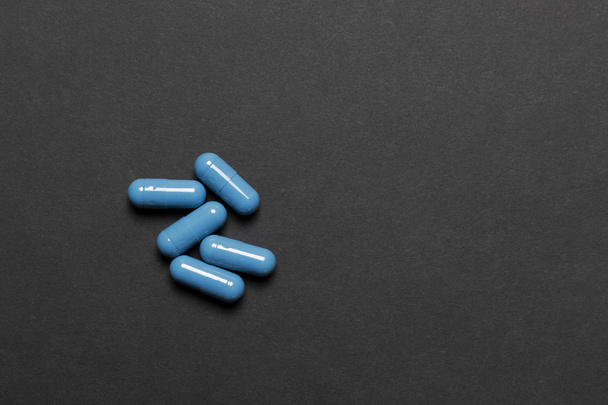 黒の背景に青い錠剤が５錠。モックアップ - 写真・画像