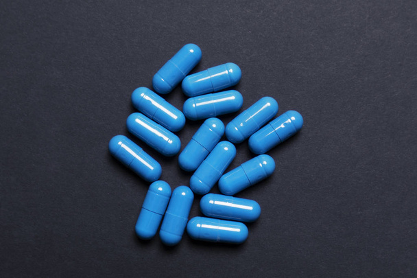 Un montón de pastillas azules sobre un fondo oscuro
 - Foto, imagen