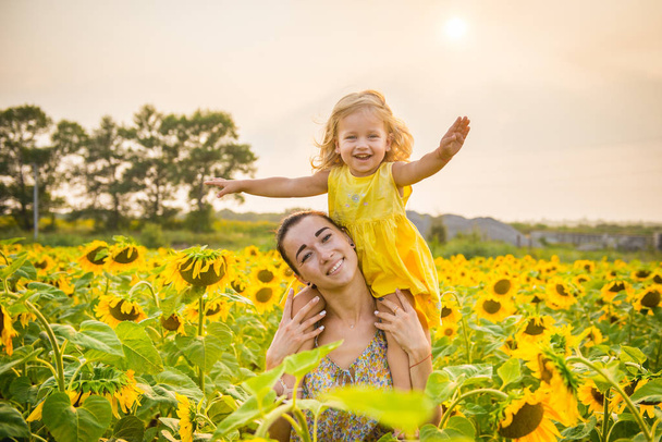 Mom and daughter in the field of sunflowers - Photo, Image
