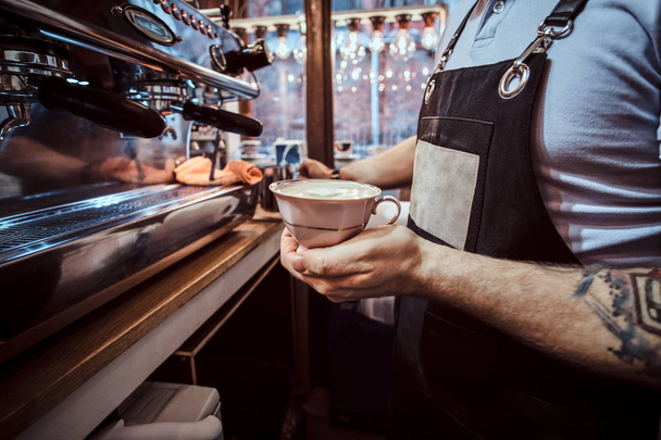 Barista gazdaság egy csésze egy aromás cappuccino, kávézó - Fotó, kép