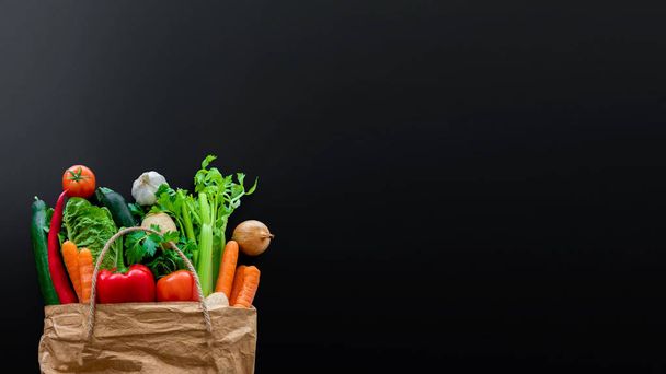 taze organik sebze kahverengi kağıt torba karanlık tablo arka planı - Fotoğraf, Görsel
