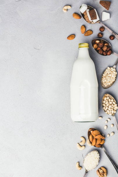 Vegan milk and ingredients on rustic background, flat lay - Foto, immagini