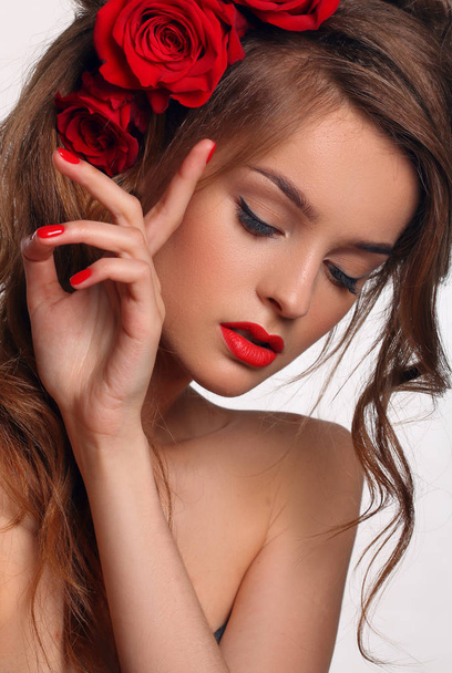 Beautiful fashion Woman with red lips and nails.Roses on hair. - Фото, зображення