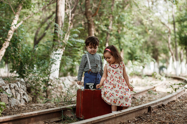Vintage tarzı fotoğraf çekimi. Erkek ve kız vintage giyim vintage aksesuarları terk edilmiş tren ve tren istasyonu ile - Fotoğraf, Görsel