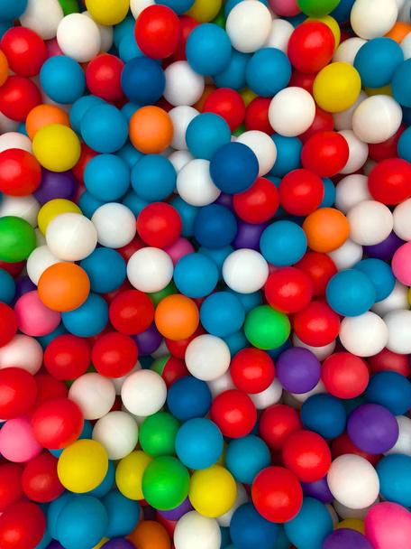 Вид зверху барвисті пластикові кульки в басейні. Пластикові барвисті кульки для гри. Барвисті пластикові кульки для гумок фон у дитячій ігровій кімнаті або ігровий майданчик для концепції дитячої святкової вечірки
 - Фото, зображення