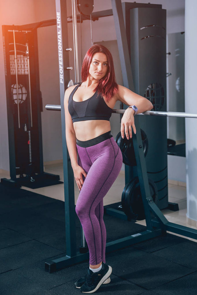 Beautiful athletic young woman making exercise at the gym. Young woman with muscular body. Fitness concept. - Zdjęcie, obraz