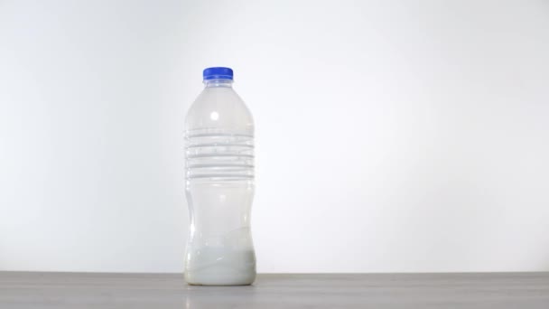 Μηδέν απόβλητα έννοια χρήση ένα γυάλινο μπουκάλι αντί για ένα πλαστικό μπουκάλι γάλα. Έννοια πράσινο και συνειδητό τρόπο ζωής. Studio που γυρίστηκε. Επαναχρησιμοποιήσιμα στις ιδέες εμπορευματοκιβώτιο πάει ποτό. Γυάλινο μπουκάλι ενάντια πλαστικό - Πλάνα, βίντεο