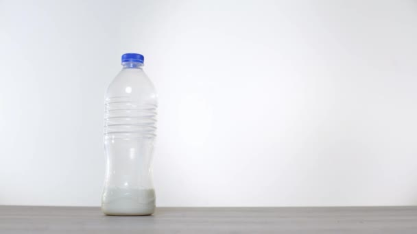 Nul afval concept gebruik een glazen fles in plaats van een plastic fles voor melk. Groene en bewuste levensstijl concept. Studio opname. Herbruikbare op de ideeën van de container ga drinken. Glazen fles tegen kunststof - Video