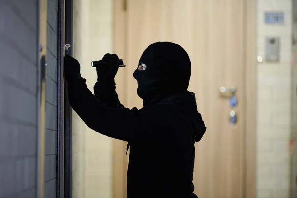 Burglar thief in mask. break-in of an apartment. - Φωτογραφία, εικόνα