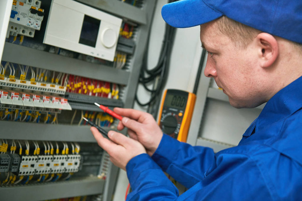 Electrician works with tester in switchbox - Zdjęcie, obraz