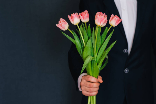 mans mano dando un ramo de tulipanes rosados
 - Foto, imagen