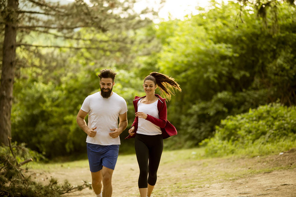 Gesund fittes und sportliches Paar läuft an Sommertagen in der Natur - Foto, Bild