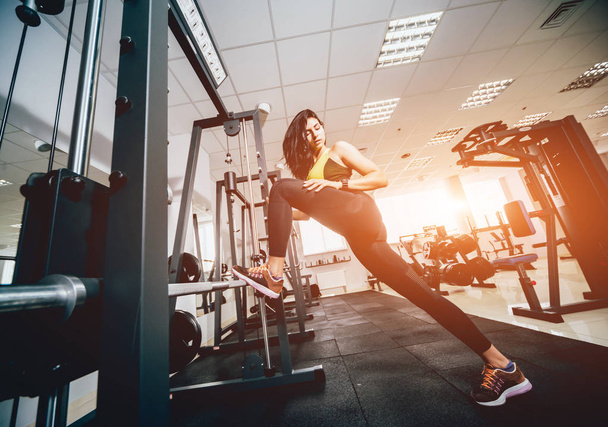 Beautiful athletic young woman making exercise at the gym. Young woman with muscular body. Fitness concept. - Fotó, kép