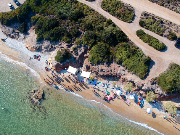 Aerial view group of people enjoying the beach time & party. Group of young people on the beach. blue sea and white sand beach in Greece. - Photo, Image