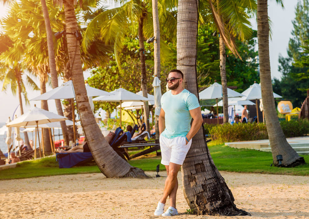 Young man on a tropical beach. Summer background - Φωτογραφία, εικόνα
