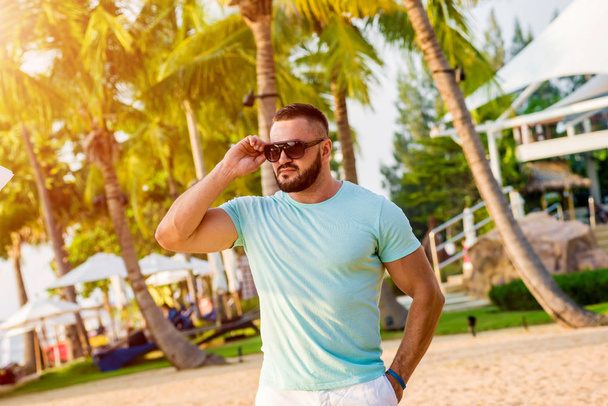 Young man on a tropical beach. Summer background - Фото, зображення