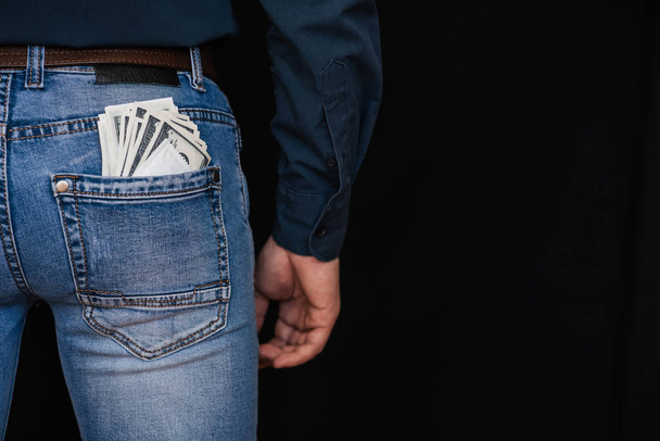 money dollars and a condom in the back pocket of mens jeans - Foto, Bild