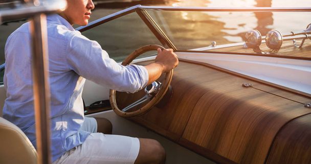 Young man on sailing yacht. Hands hold steering wheel. Background - Φωτογραφία, εικόνα