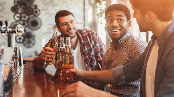 Přátelé pití piva a chatování na přepážce v hospodě - Fotografie, Obrázek